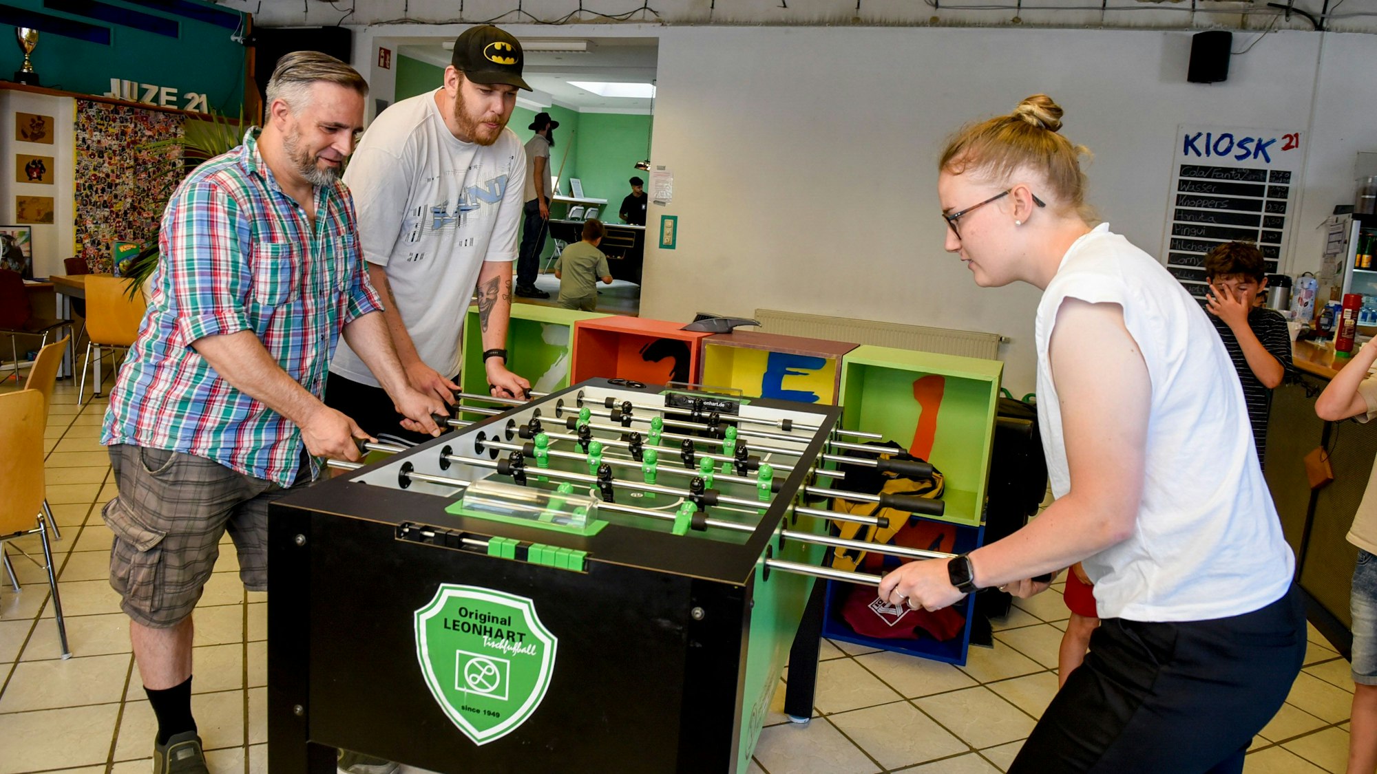Das Foto zeigt die Hauptamtlichen Jens Römpp, Simon Mohr und Hannah Scheffler beim Kickern.