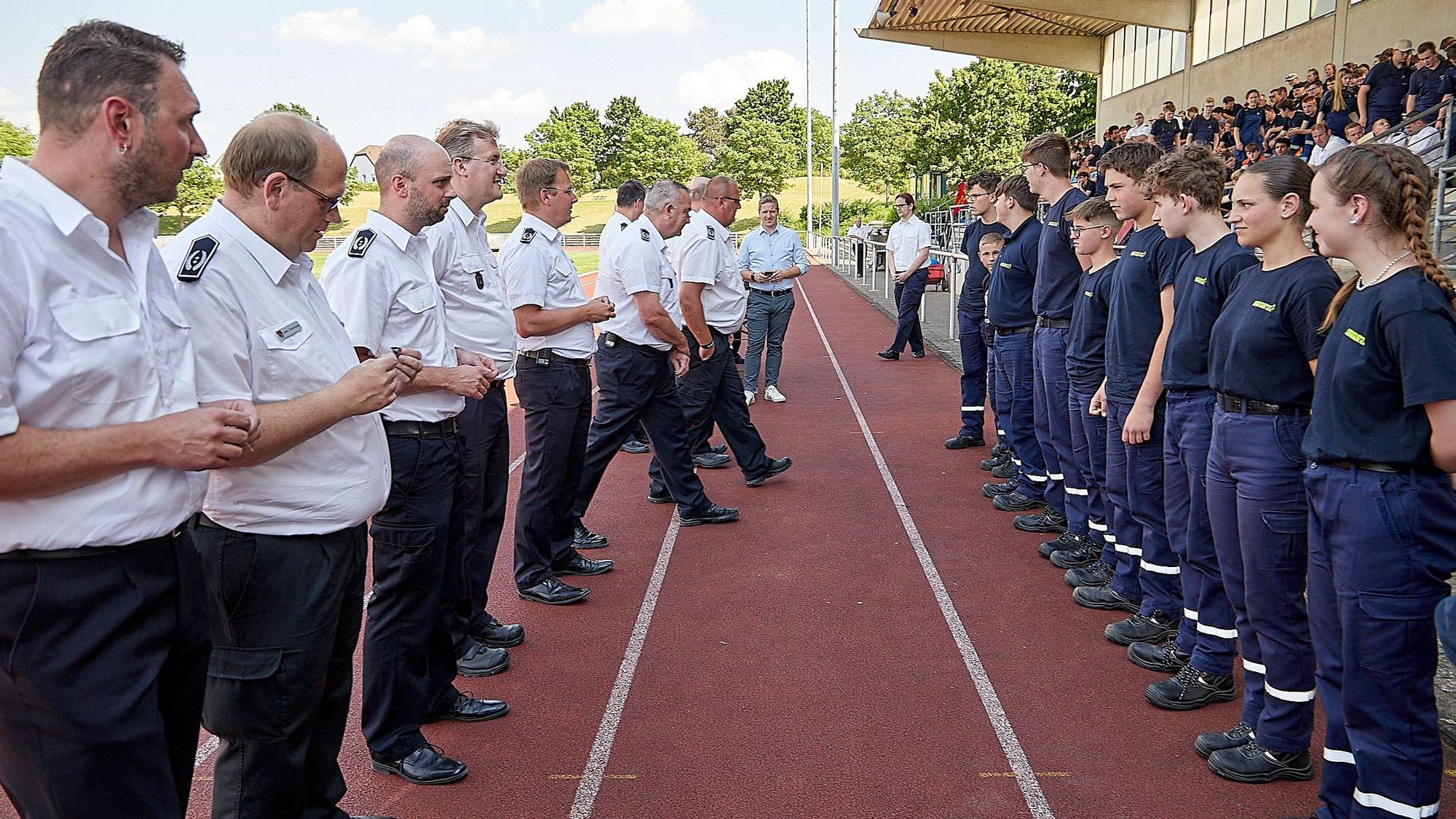 Eine Reihe Männer steht einer Reihe Jugendlicher gegenüber: Es sind Leiter der Feuerwehren aus dem Kreis Euskirchen, die Jugendfeuerwehrleuten die Leistungsspange übergeben.