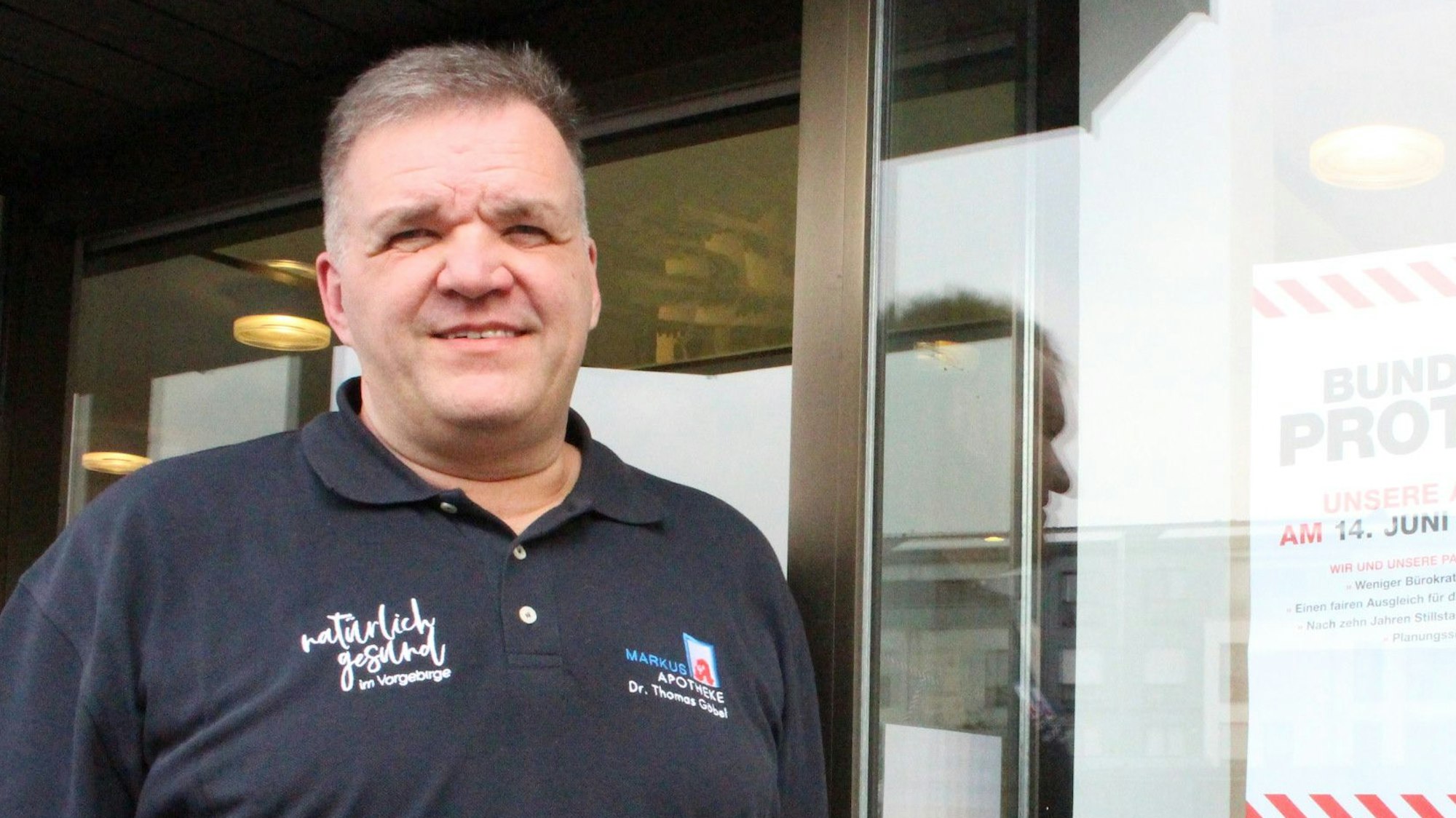 Dr. Thomas Göbel steht vor einer Apotheke.