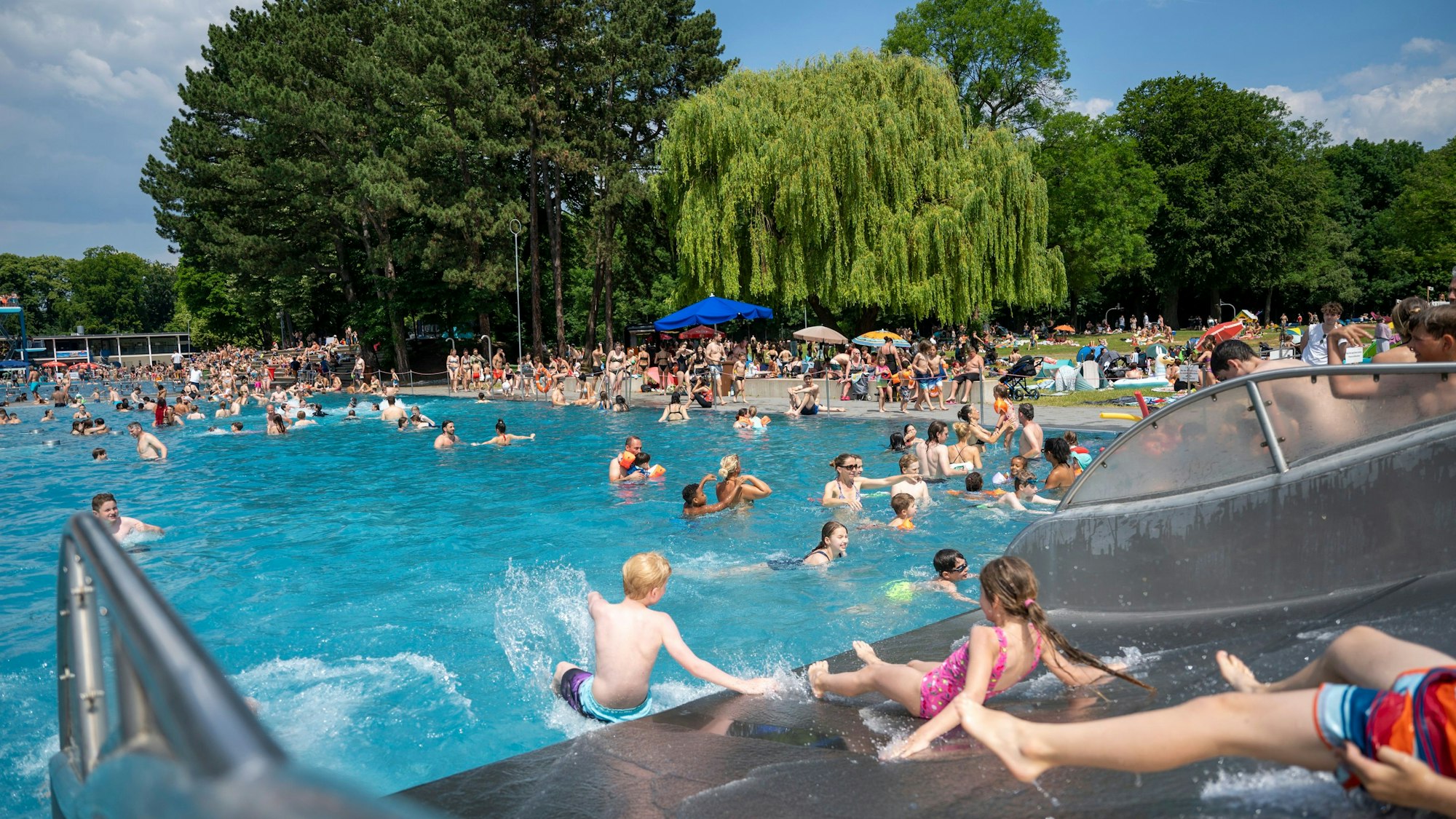 Junge Menschen rutschen auf einer Wasserrutsche.