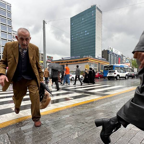 Fußgänger überqueren bei Regen eine Straße in Ankara.