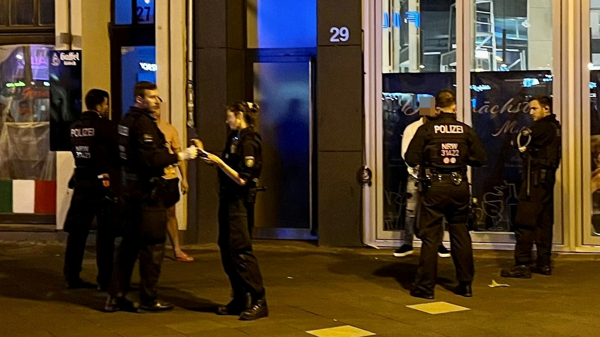 Einsatzkräfte kontrollieren zwei Männer auf den Ringen.