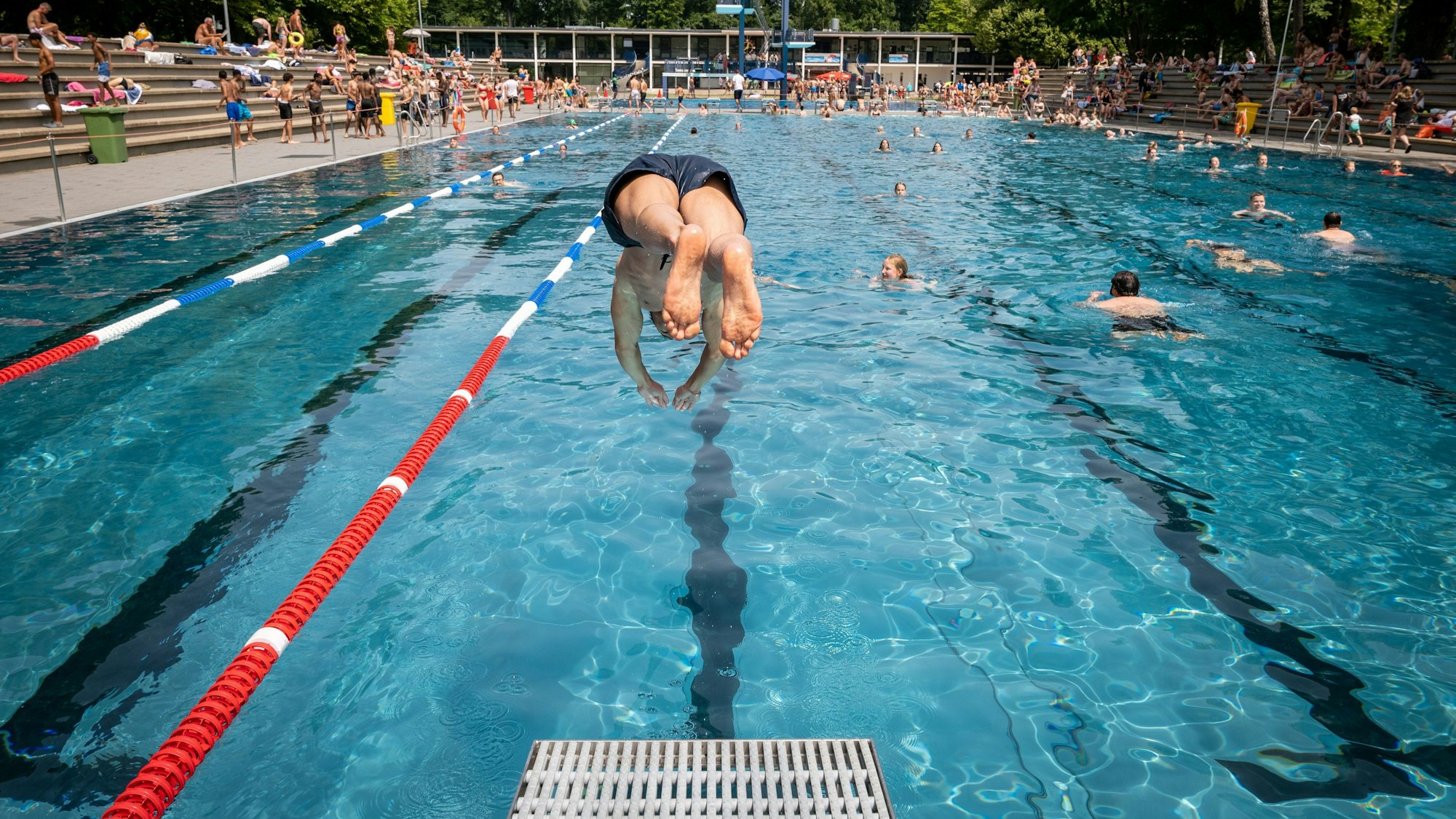 ARCHIV - 18.06.2022, Nordrhein-Westfalen, Köln: Ein Mann springt im Stadionbad mit einem Kopfsprung vom Bock ins Wasser.