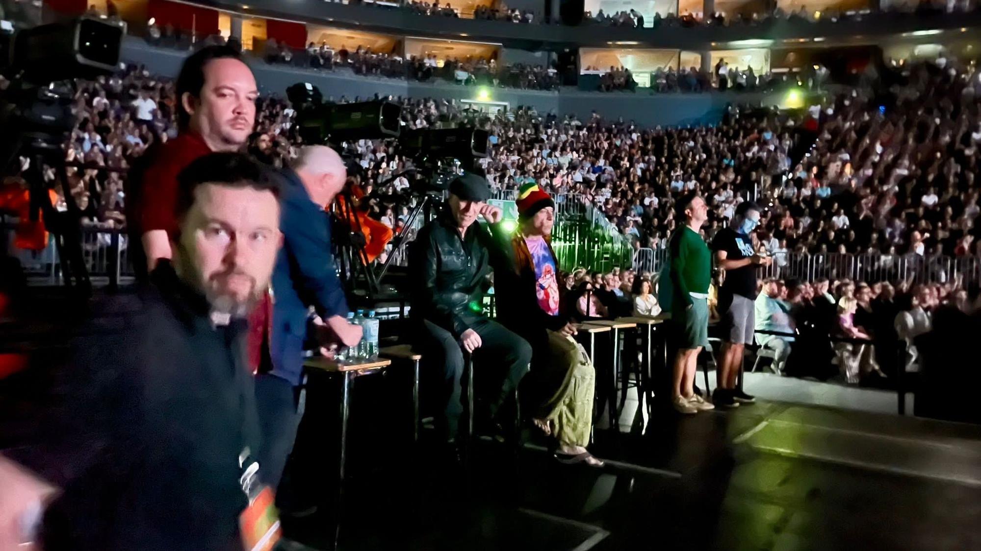 Bruce Springsteen und andere Personen stehen in der Lanxess-Arena beim Konzert von Peter Gabriel.