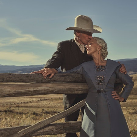 Harrison Ford und Helen Mirren sind gehoben im Stil der 20er gekleidet, Ford trägt einen Cowboy-Hut. Sie lehnen zusammen an einem Holzzaun, im Hintergrund die Landschaft von Montana.