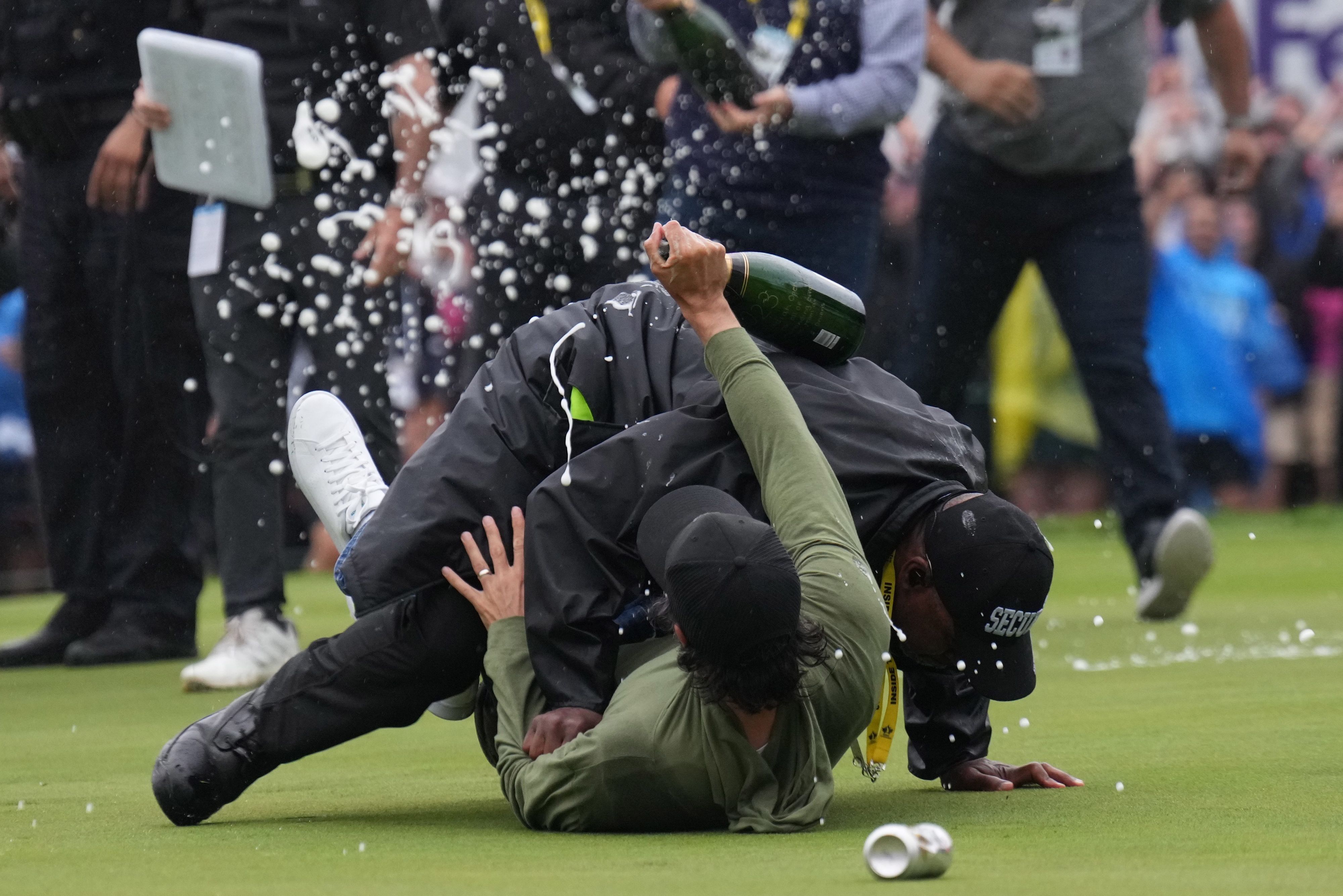 Adam Hadwin (r), Profi-Golfer aus Kanada, wird von einem Sicherheitsbeamten aufgehalten, während er versucht, mit dem Sieger zu feiern.
