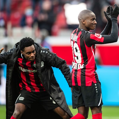 Leverkusens Jeremie Frimpong (l) schlägt Moussa Diaby nach der Partie auf den Hintern.