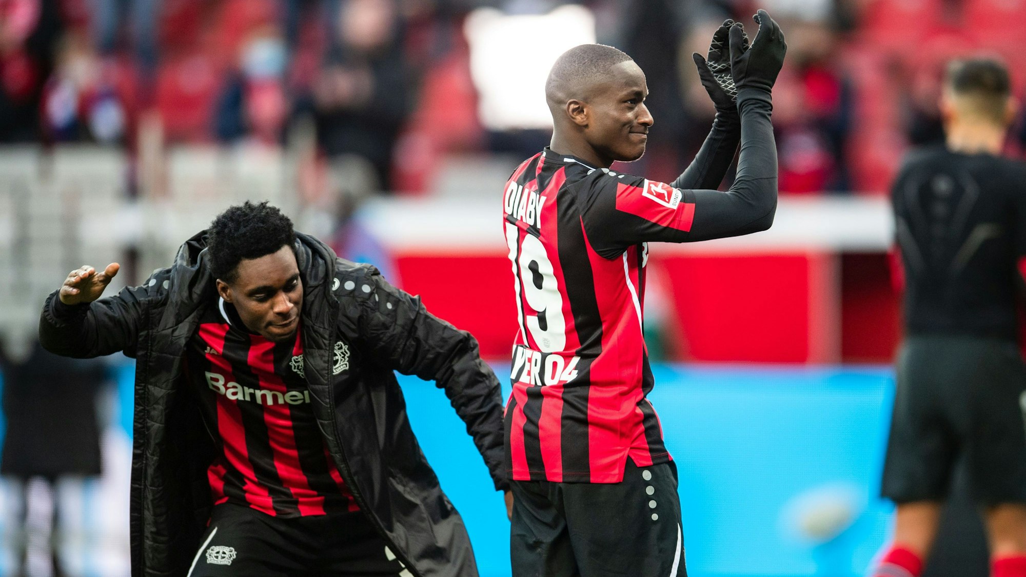 Leverkusens Jeremie Frimpong (l) schlägt Moussa Diaby nach der Partie auf den Hintern.