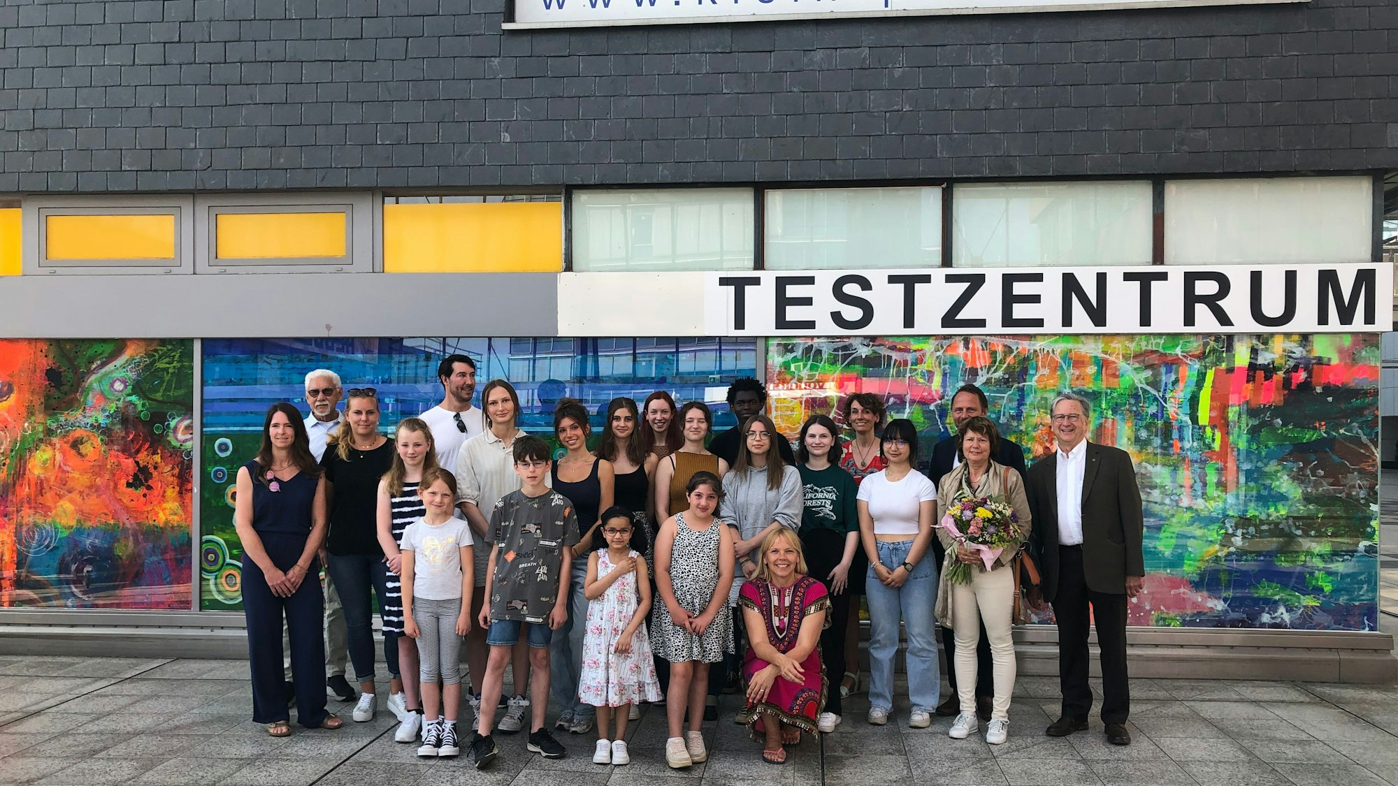 Die Beteiligten vor bunten Leinwänden