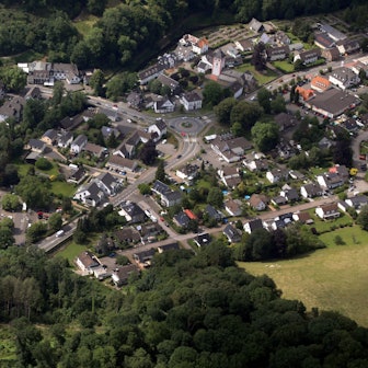 Eine Luftaufnahme von Odenthal: Häuser stehen nahe von Feldern und Bäumen.