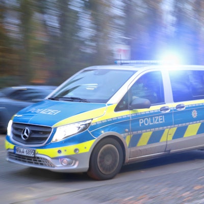 Ein Polizeiauto fährt mit Blaulicht durch eine Straße zum Einsatz.