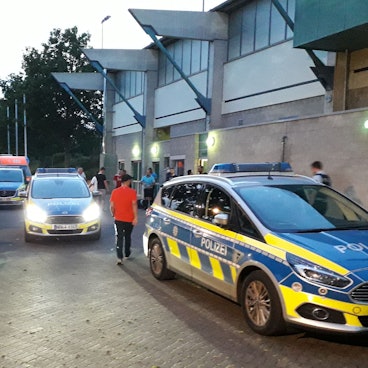 Zahlreiche Polizeifahrzeuge stehen vor dem Erftstadion in Euskirchen. Die Beamten waren nach Ausschreitungen bei einem Fußballspiel alarmiert worden.