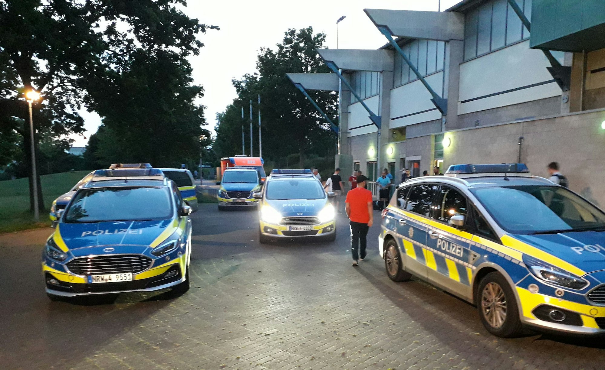 Fünf Streifenwagen stehen vor der Spielstätte bereit, nachdem es dort zu Ausschreitungen gekommen war.