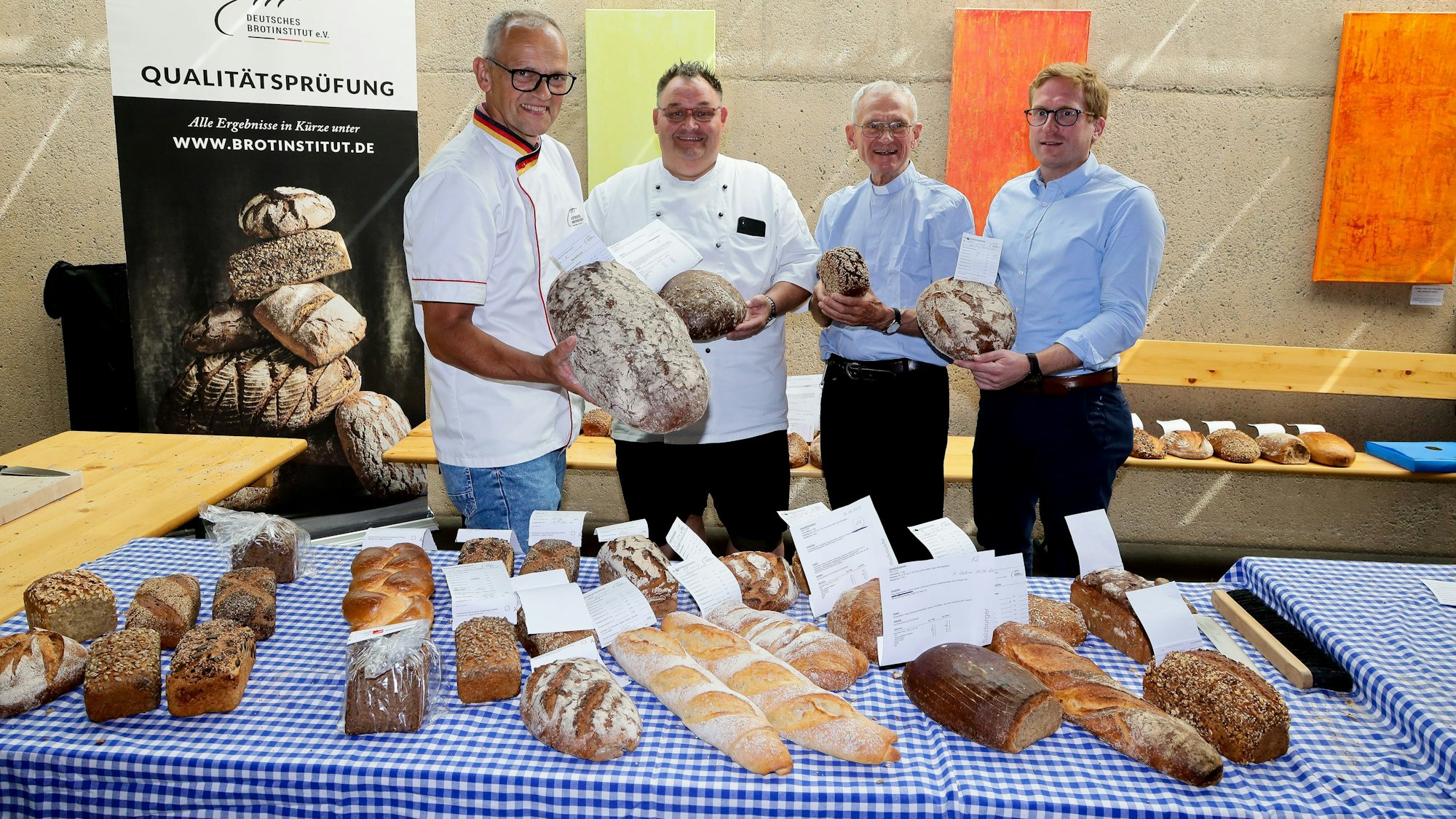 Tester Karl Ernst Schmalz, Obermeister Guido Boveleth, Pfarrer Franz Meurer, Peter Ropertz vor einem Tisch mit Broten