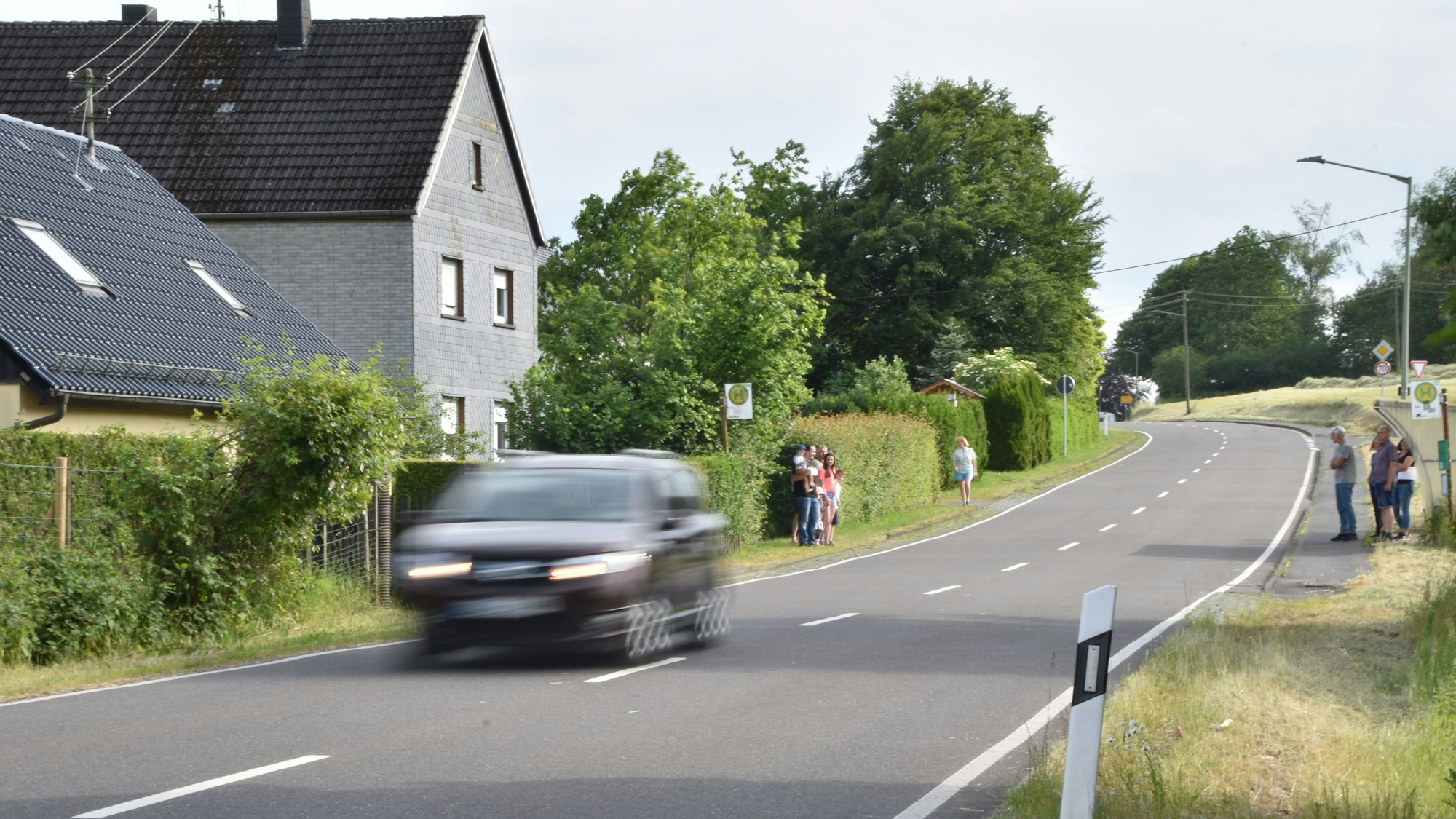 Ein Auto fährt eine Landstraße entlang.