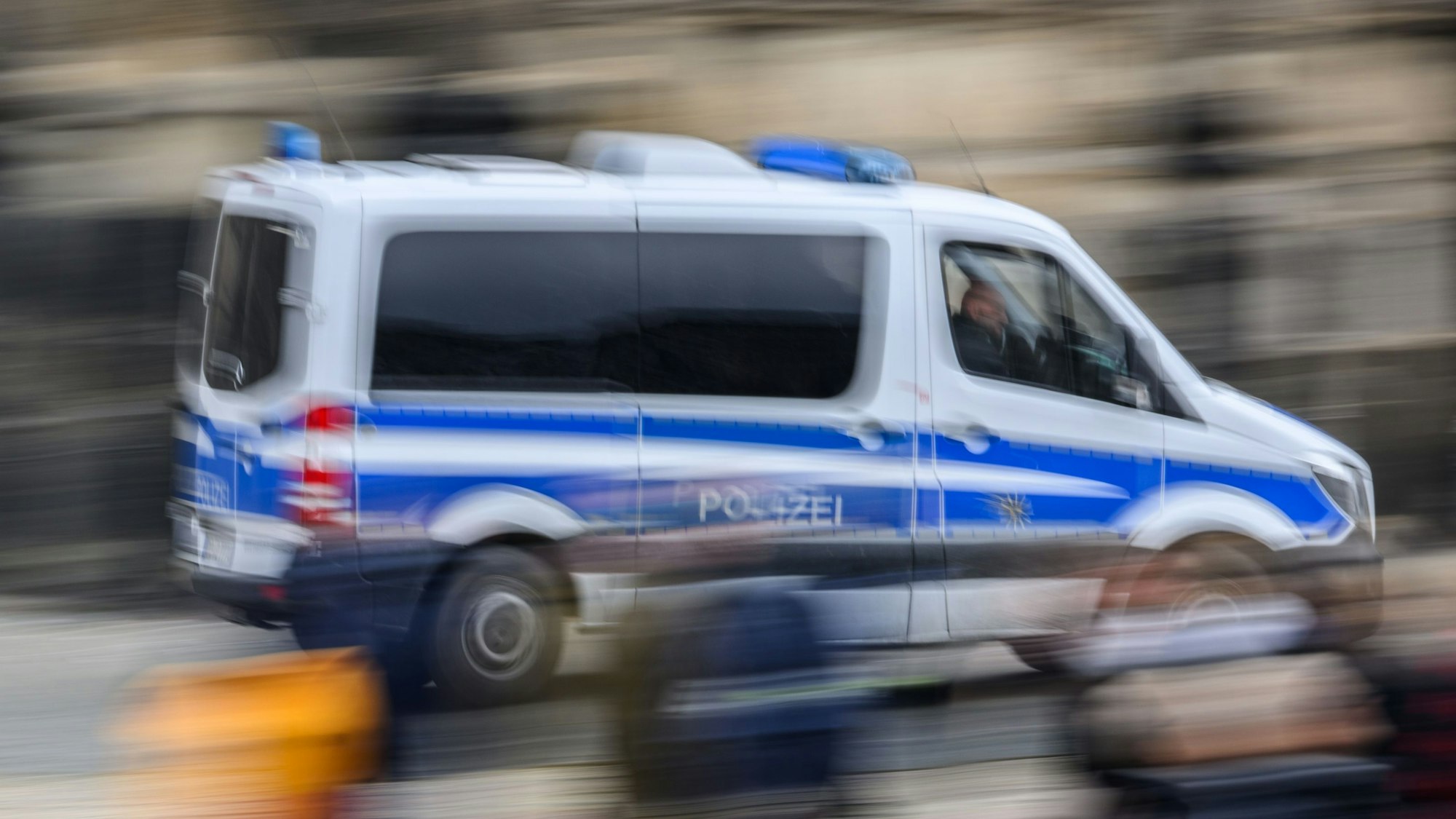 Ein Polizeiauto fährt die Straße entlang.