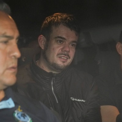 Joran van der Sloot beim Verlassen des Gefängnisses in Lima. Neben ihm sind Polizeibeamte.