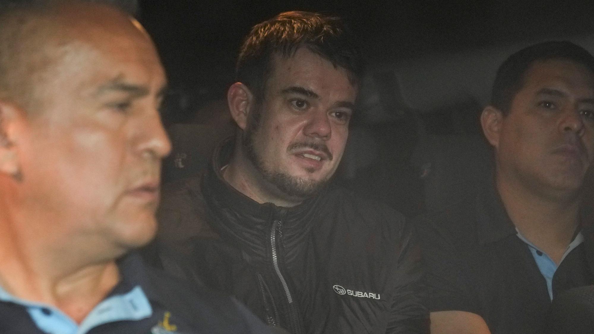 Joran van der Sloot beim Verlassen des Gefängnisses in Lima. Neben ihm sind Polizeibeamte.
