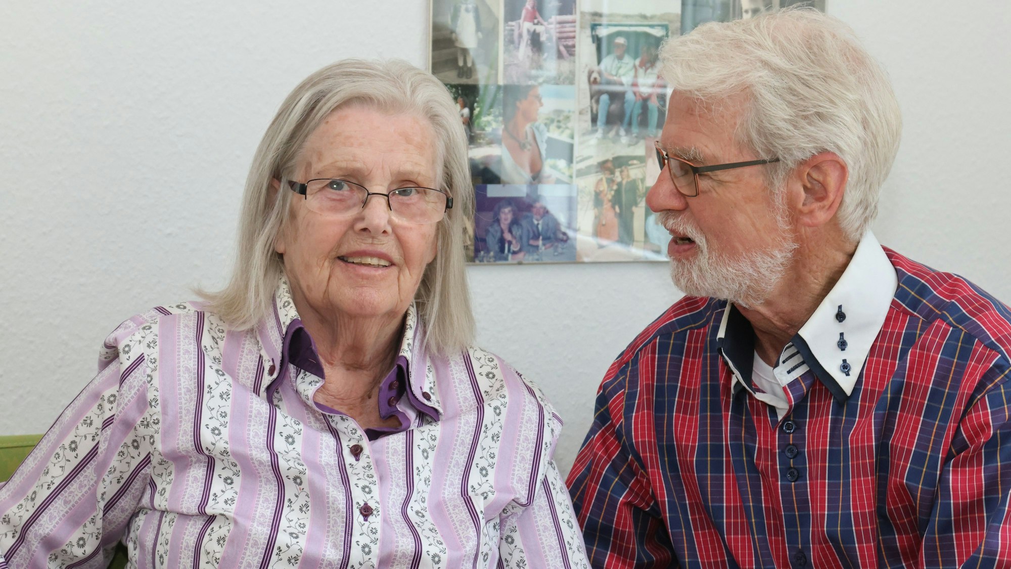 Ein älteres Ehepaar sitzt nebeneinander, der Mann schaut seine Frau an.