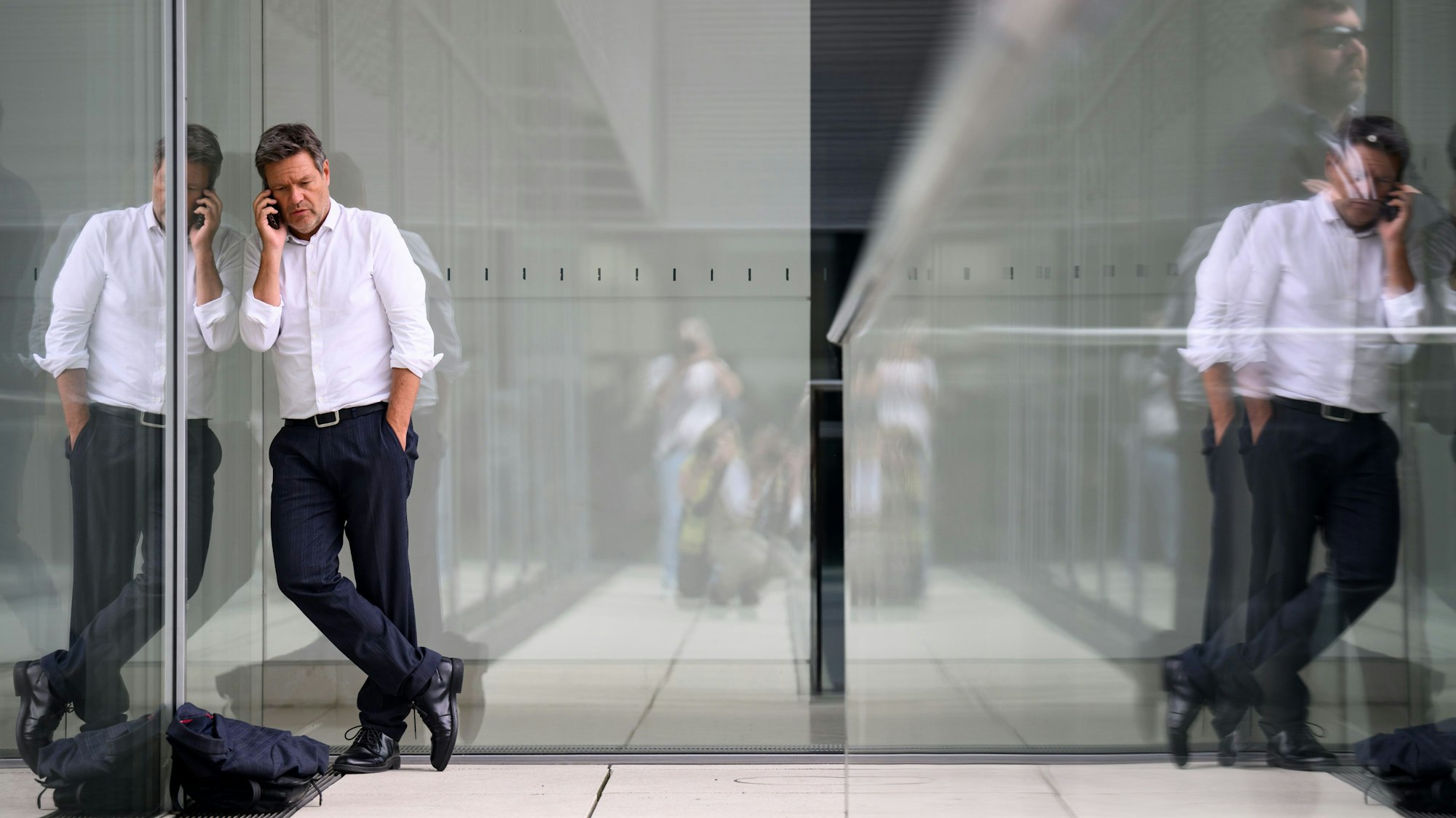Robert Habeck (Bündnis 90/Die Grünen), Vizekanzler und Bundesminister für Wirtschaft und Klimaschutz, steht nach einer Besprechung in einem Sitzungssaal der SPD-Fraktion im Deutschen Bundestag auf einer Terrasse und telefoniert.