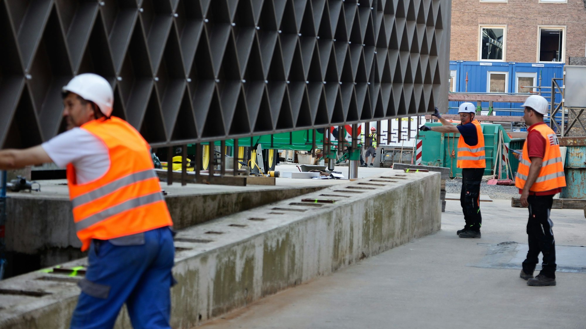 Drei Männer helfen beim Einsetzen des letzten Seitenteils.
