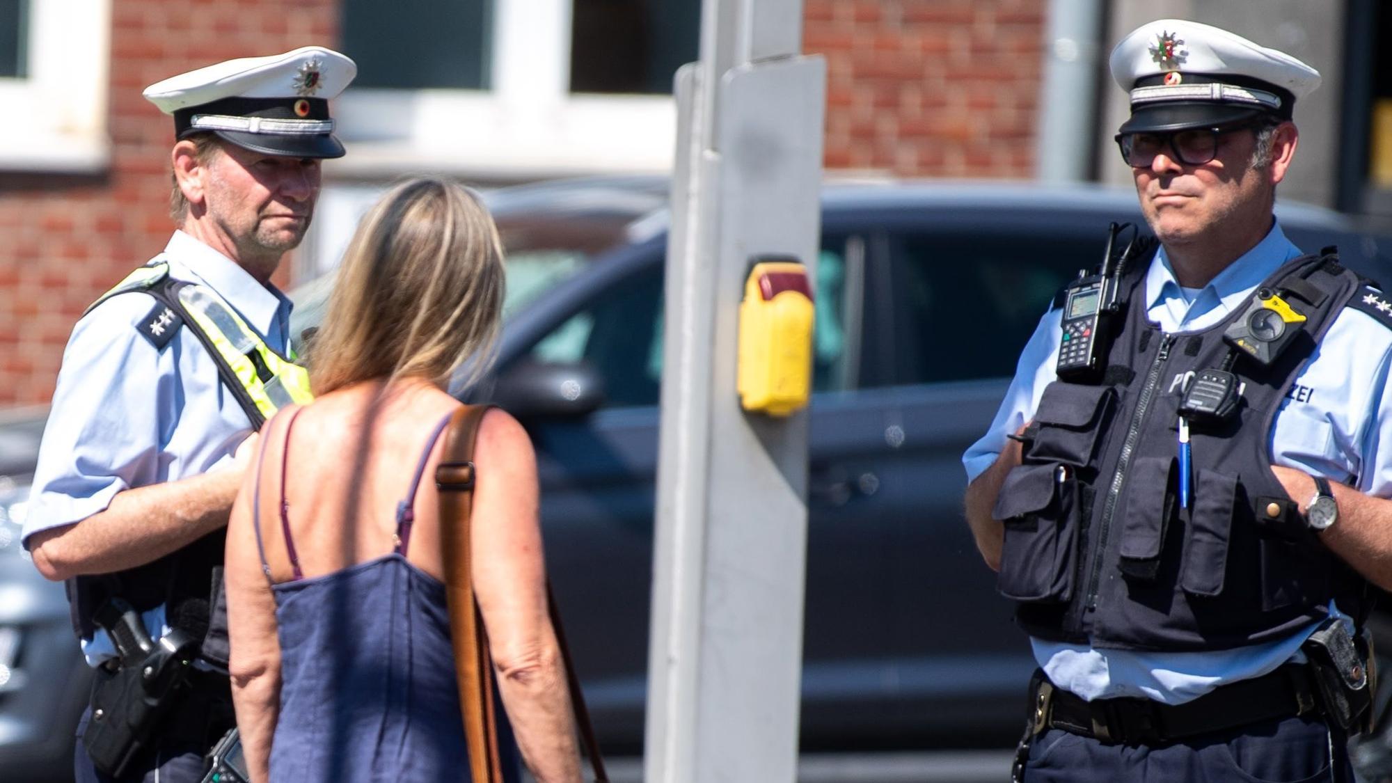 Eine Frau spricht in Euskirchen mit zwei Polizisten.