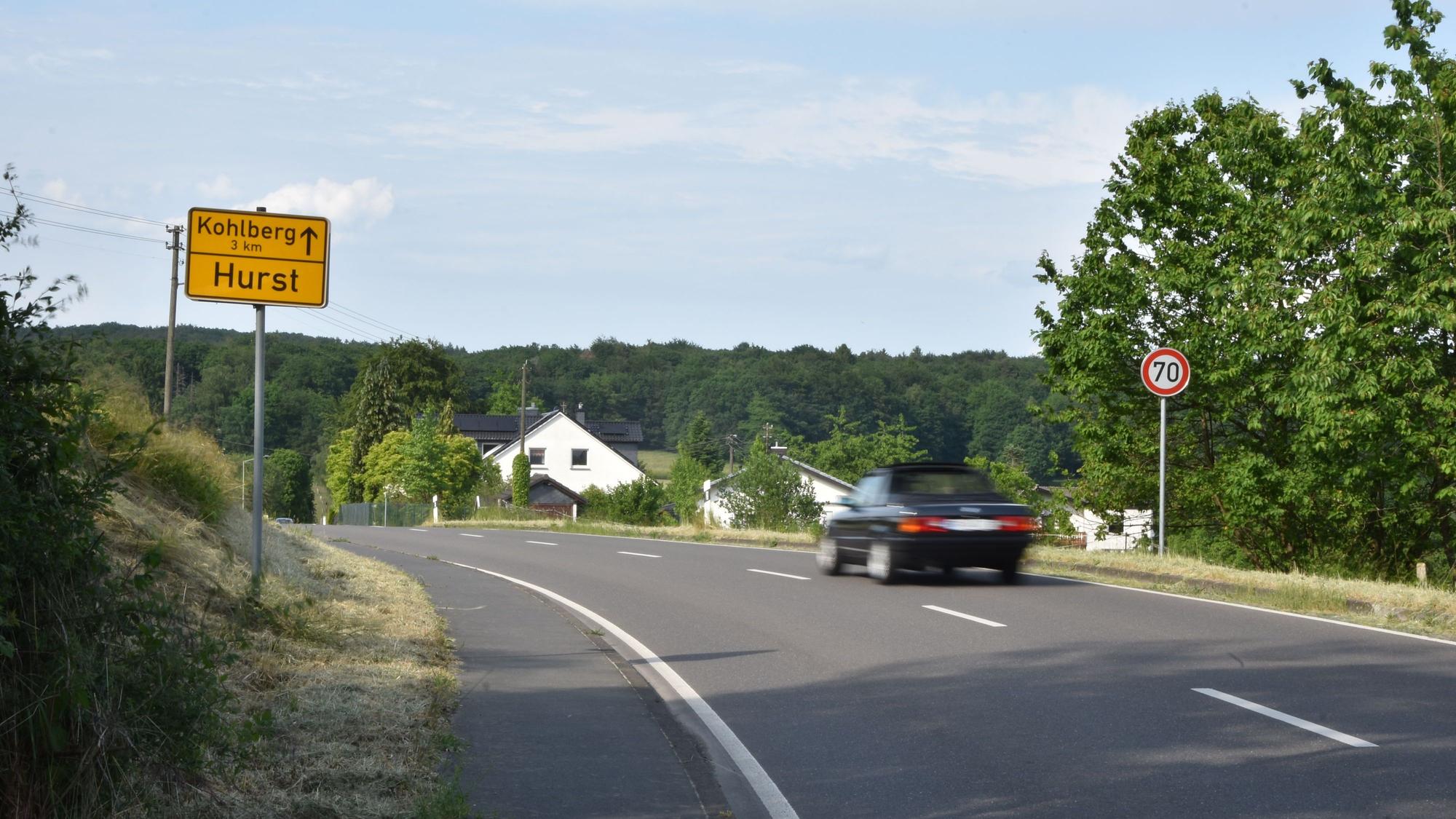 Ein Auto fährt über eine Landstraße.