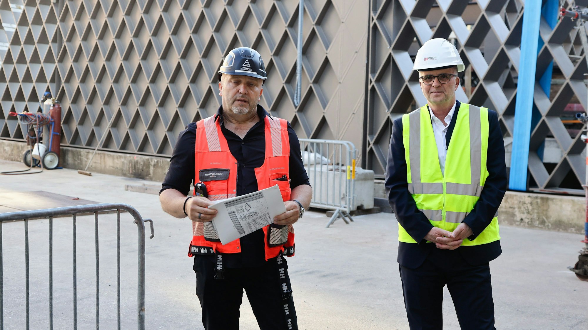 Matthias Zoppelt (Bauleiter, Zac Bauleitung Gesellschaft) und Markus Gretemann (Beigeordneter für Planen und Bauen der Stadt Köln) stehen nebeneinander auf der Baustelle.