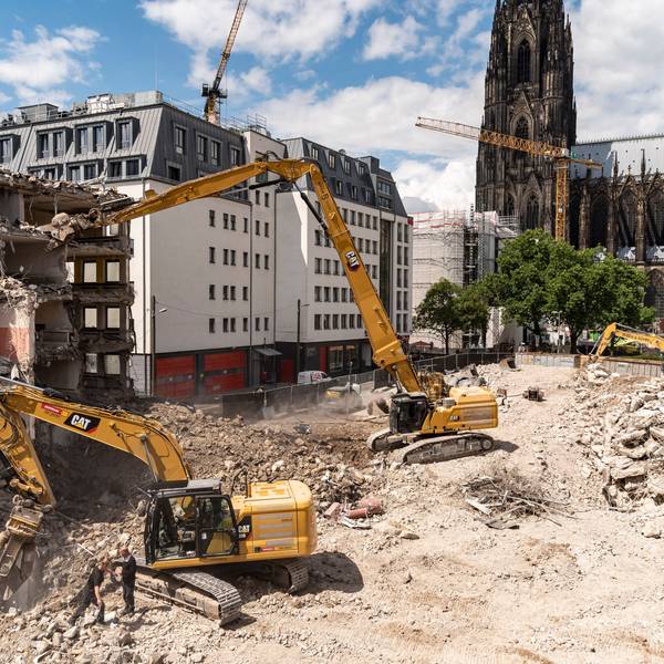 Das Bild zeigt Bagger, die ein Gebäude nahe des Kölner Doms abbrechen.