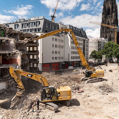 Das Bild zeigt Bagger, die ein Gebäude nahe des Kölner Doms abbrechen.
