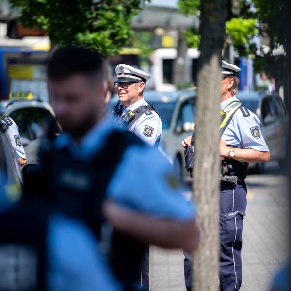 Drei Polizisten beobachten das Geschehen auf dem Vorplatz des Euskirchener Bahnhofs.