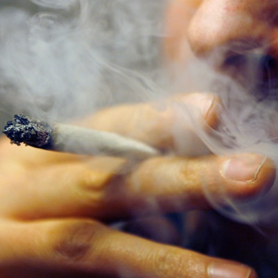 Ein Mann raucht einen Joint mit Marihuana.