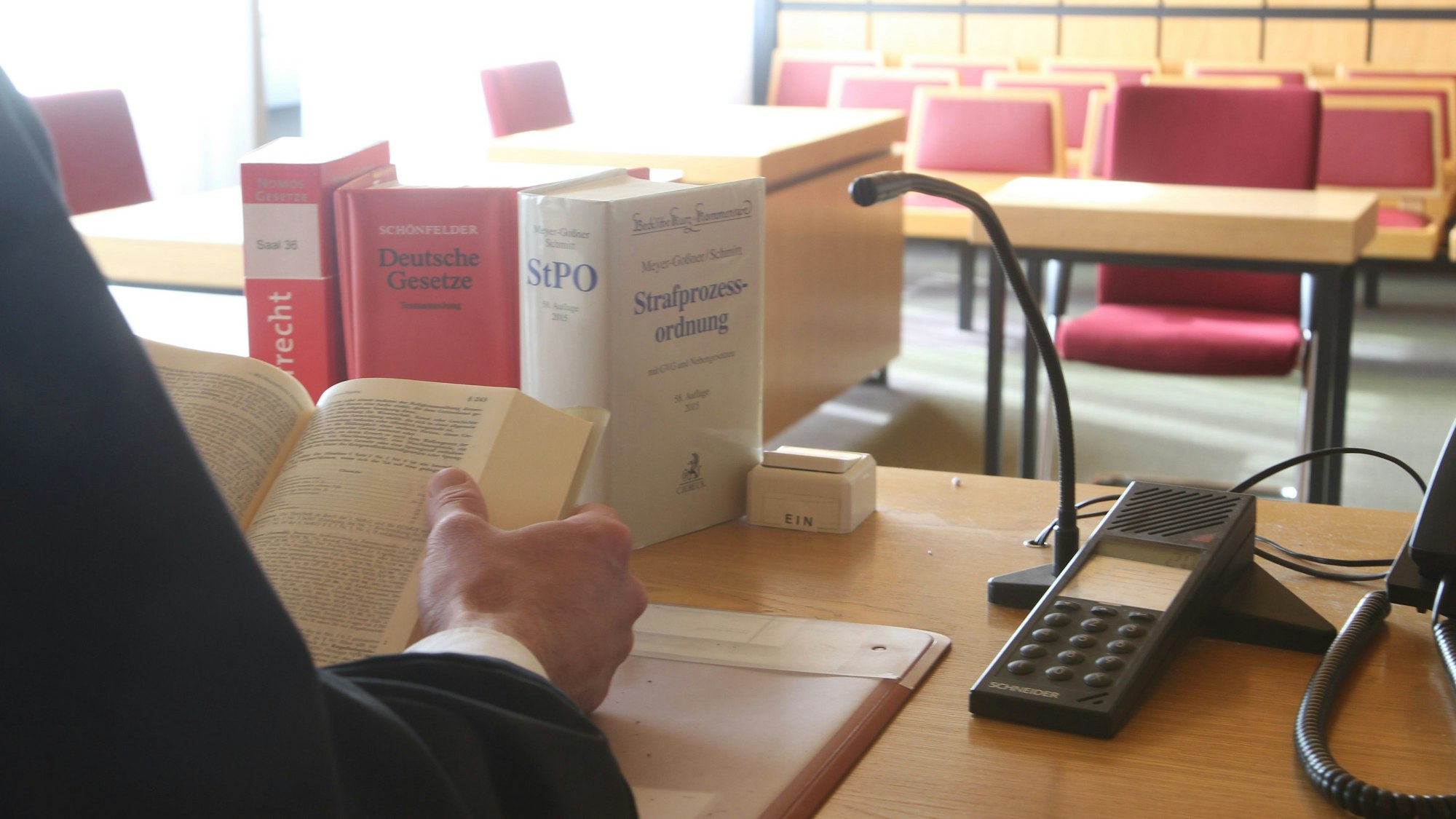 Der Gerichtssaal im Amtsgericht Siegburg. Auf einem Tisch liegen Akten und Gesetzbücher.