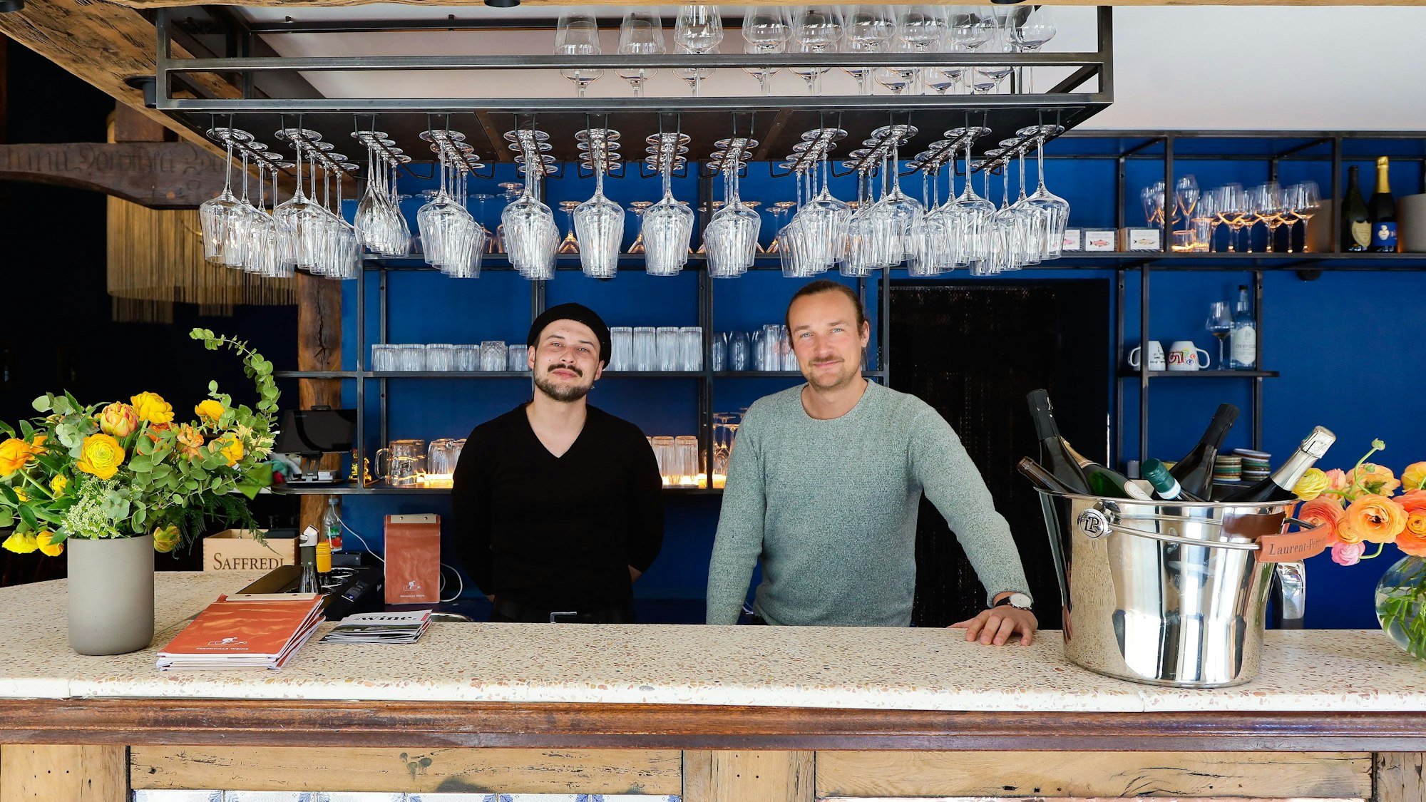 Yngwie Erich und Adrian Röpe stehen hinter der Theke ihrer Weinbar.