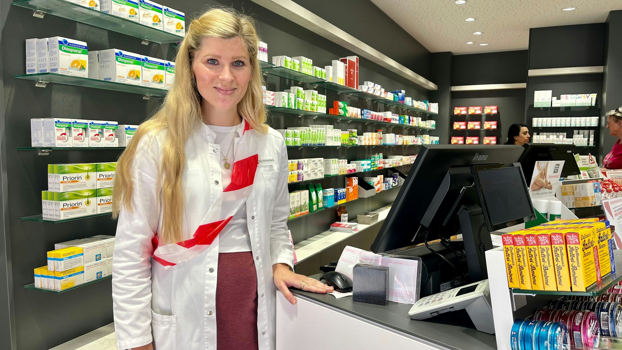 Apothekerin mit Absperrband um die Dienstkleidung.