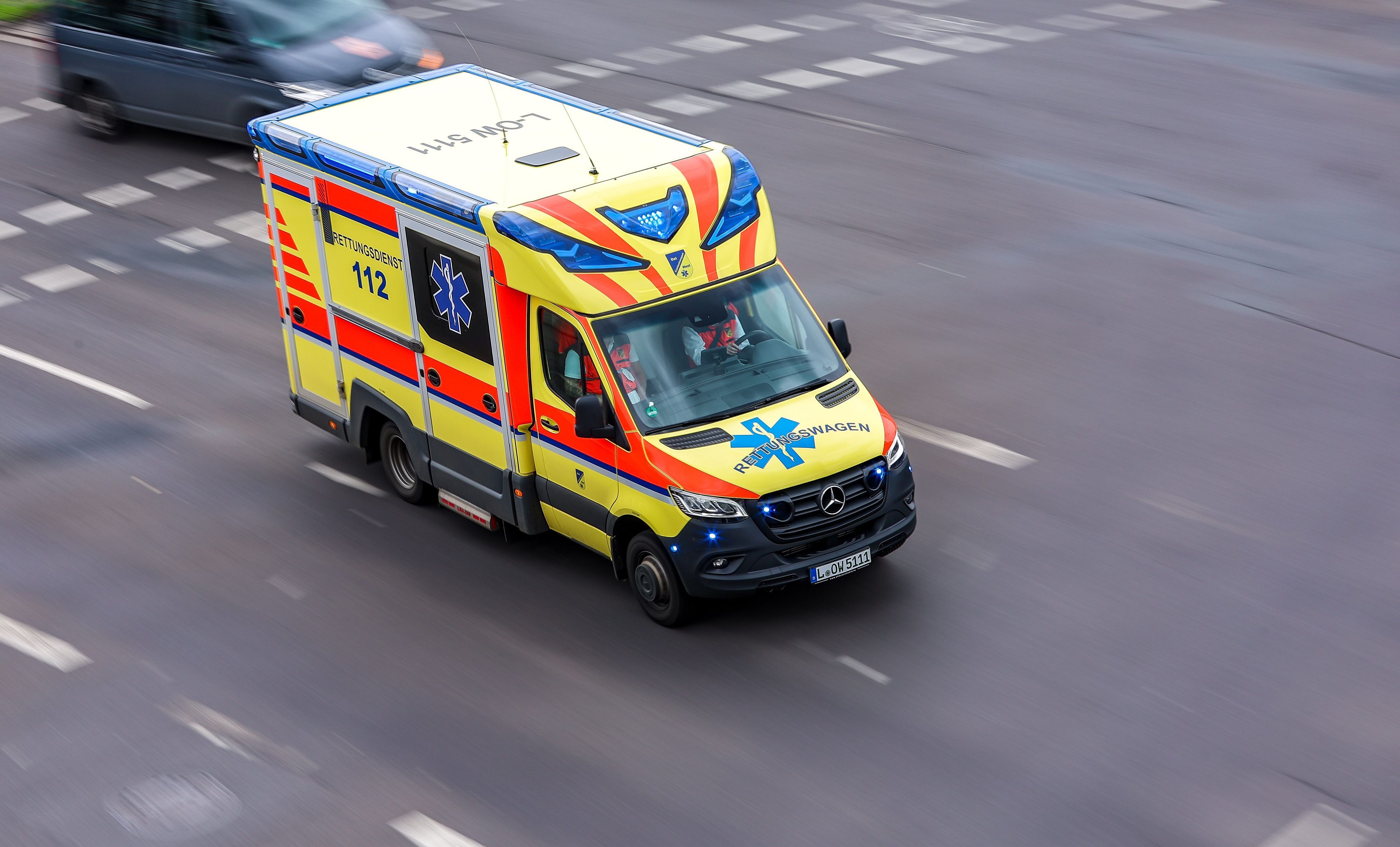 Ein Rettungswagen fährt mit Blaulicht über Kreuzung