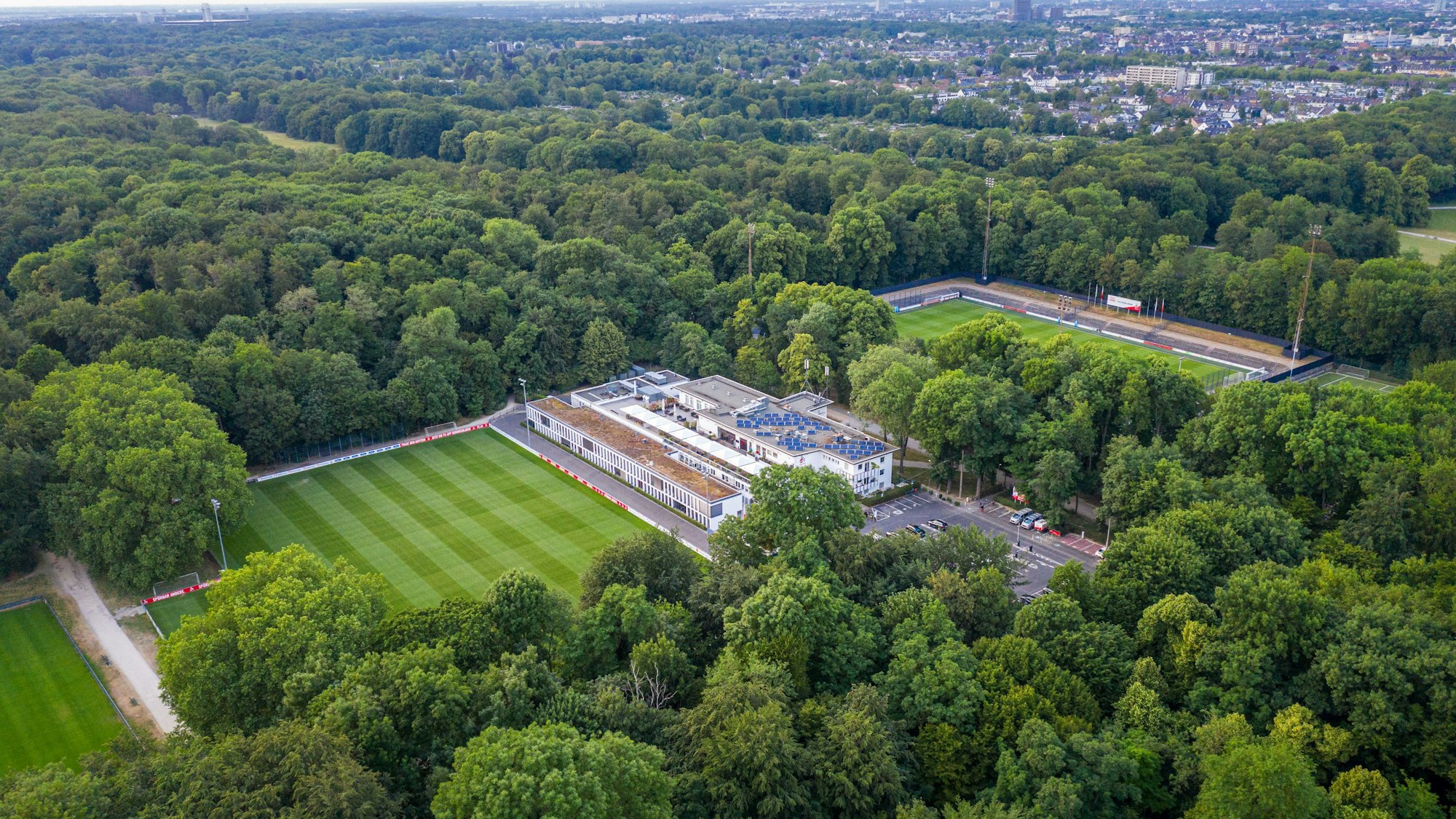 Das Geißbockheim von oben betrachten: Oben links in den Wäldern ist die Gleueler Wiese zu sehen.