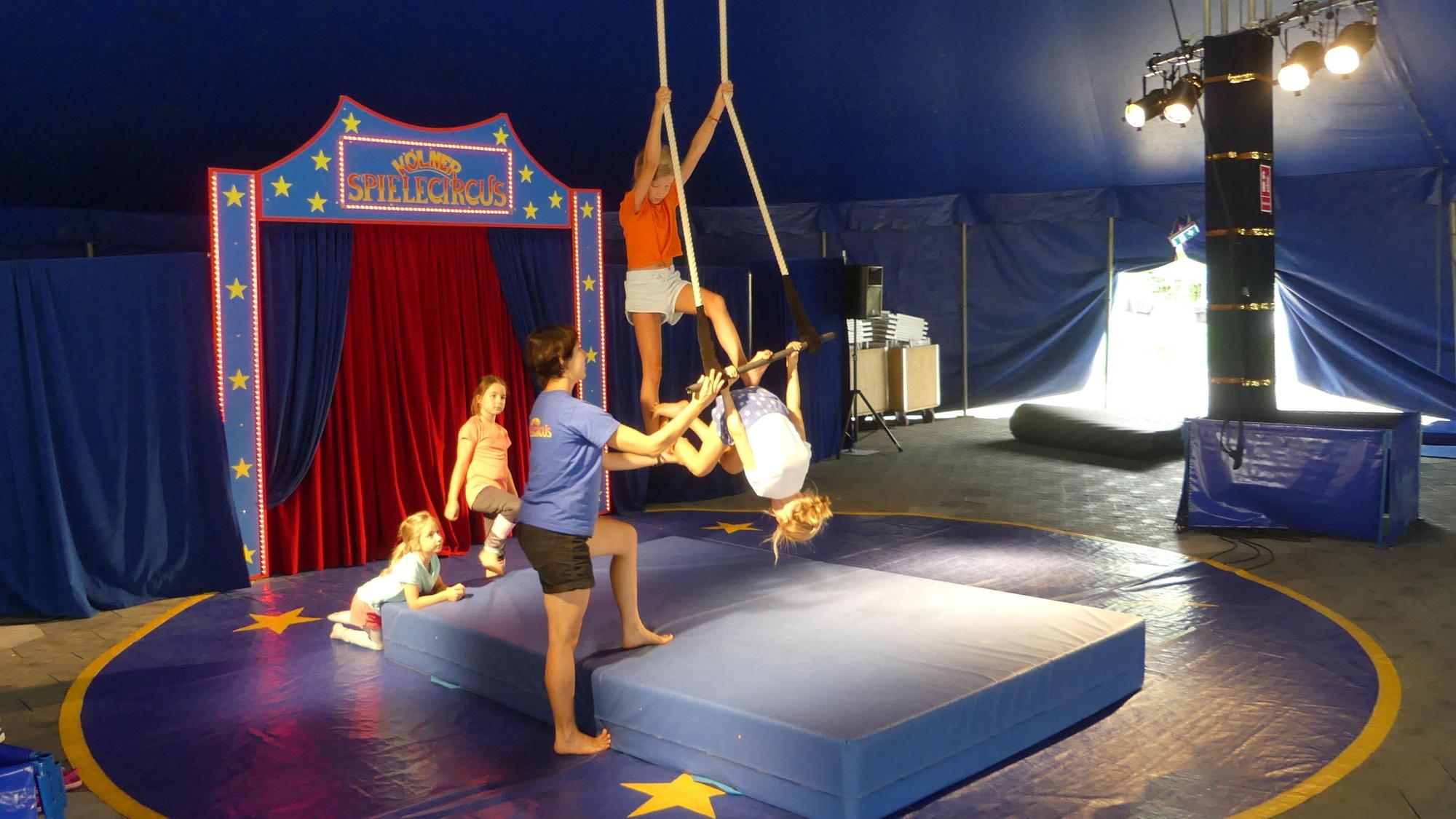Kinder am Trapez in der Manege des Spielecircus.