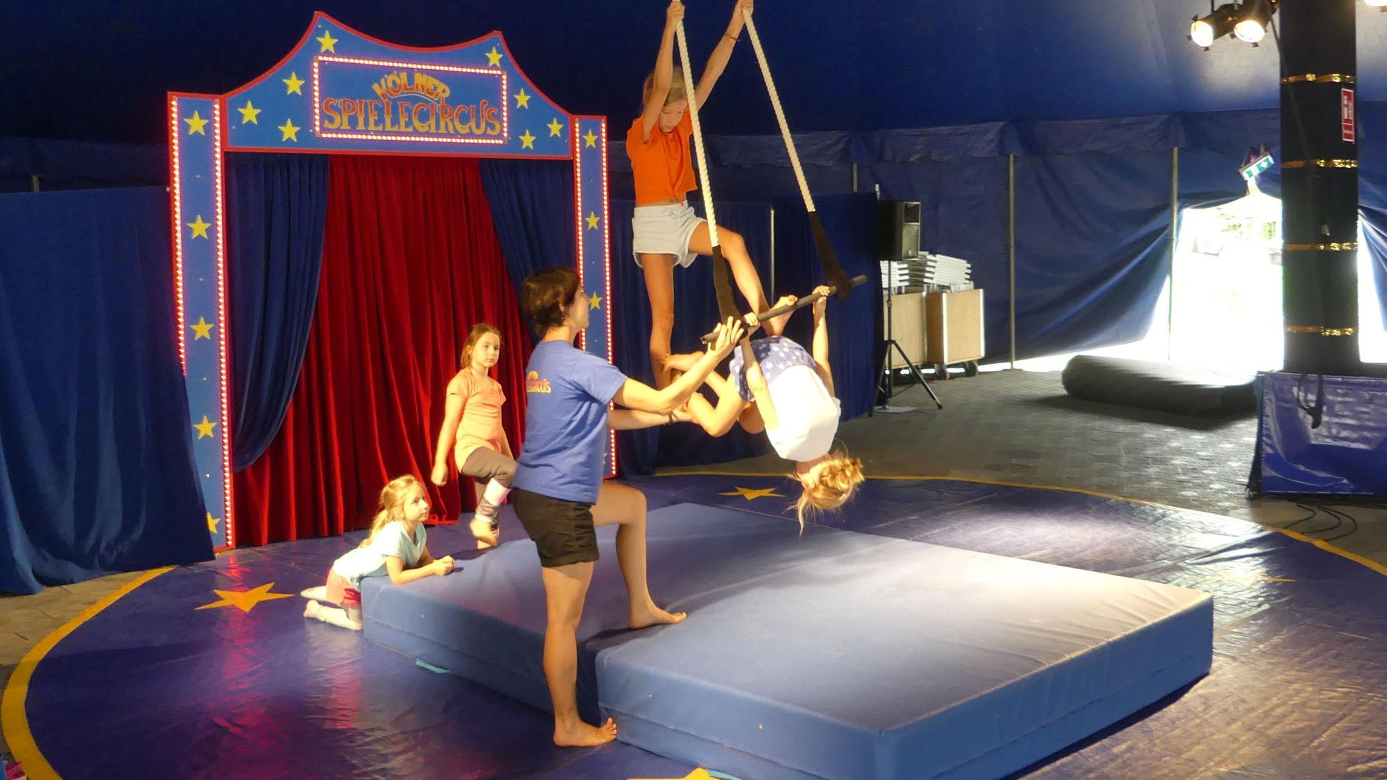 Kinder führen in der Manege des Kölner Spielcircus eine Artistennummer am Seil auf.