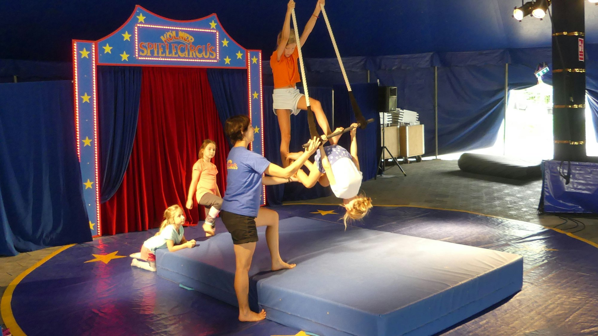 Kinder führen in der Manege des Kölner Spielcircus eine Artistennummer am Seil auf.