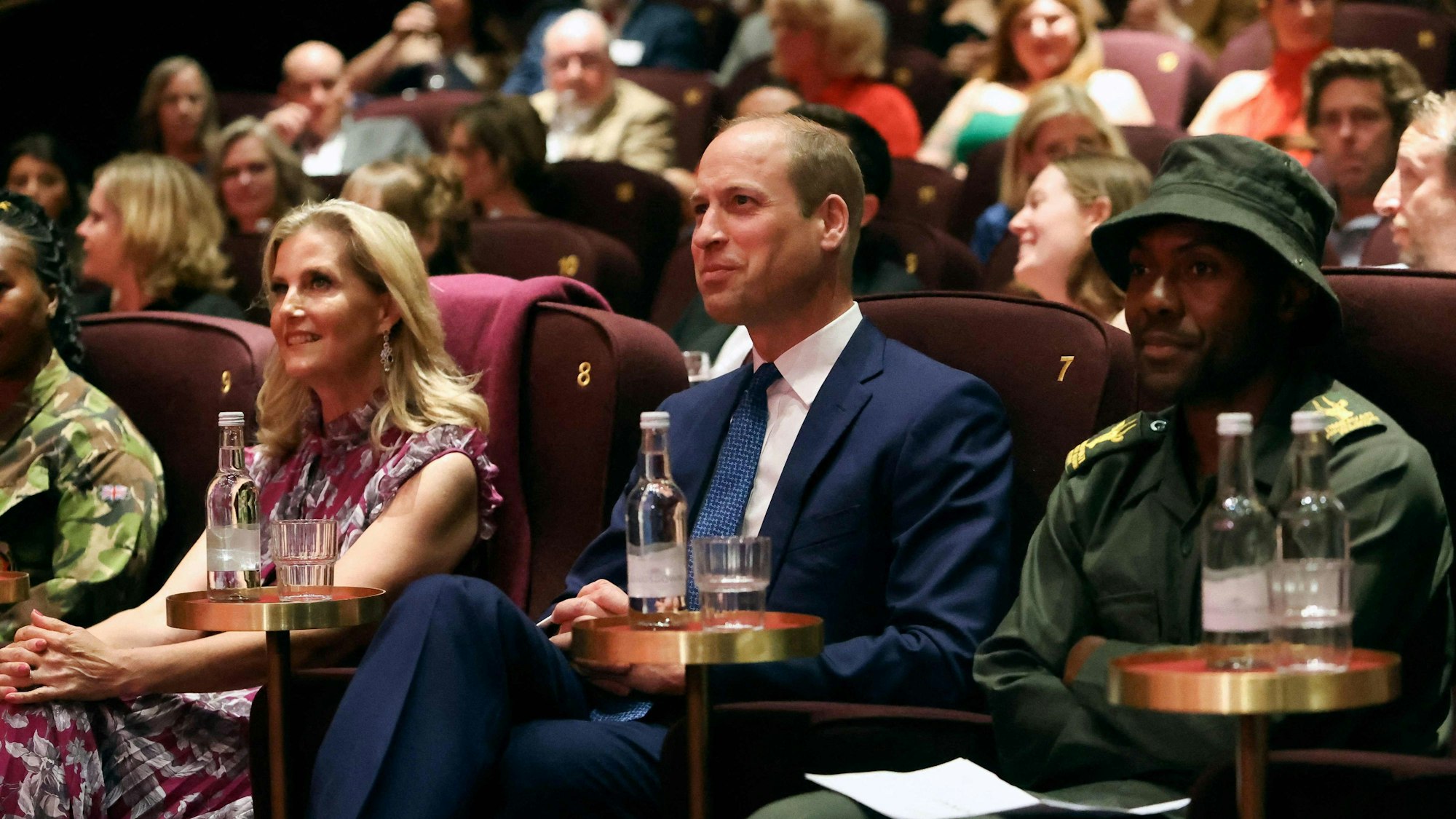 Herzogin Sophie und Prinz William bei der Vorführung der Nashorn-Dokumentation „Rhino Man“. Sie schauen auf die Leinwand, um sie herum sind Menschen.