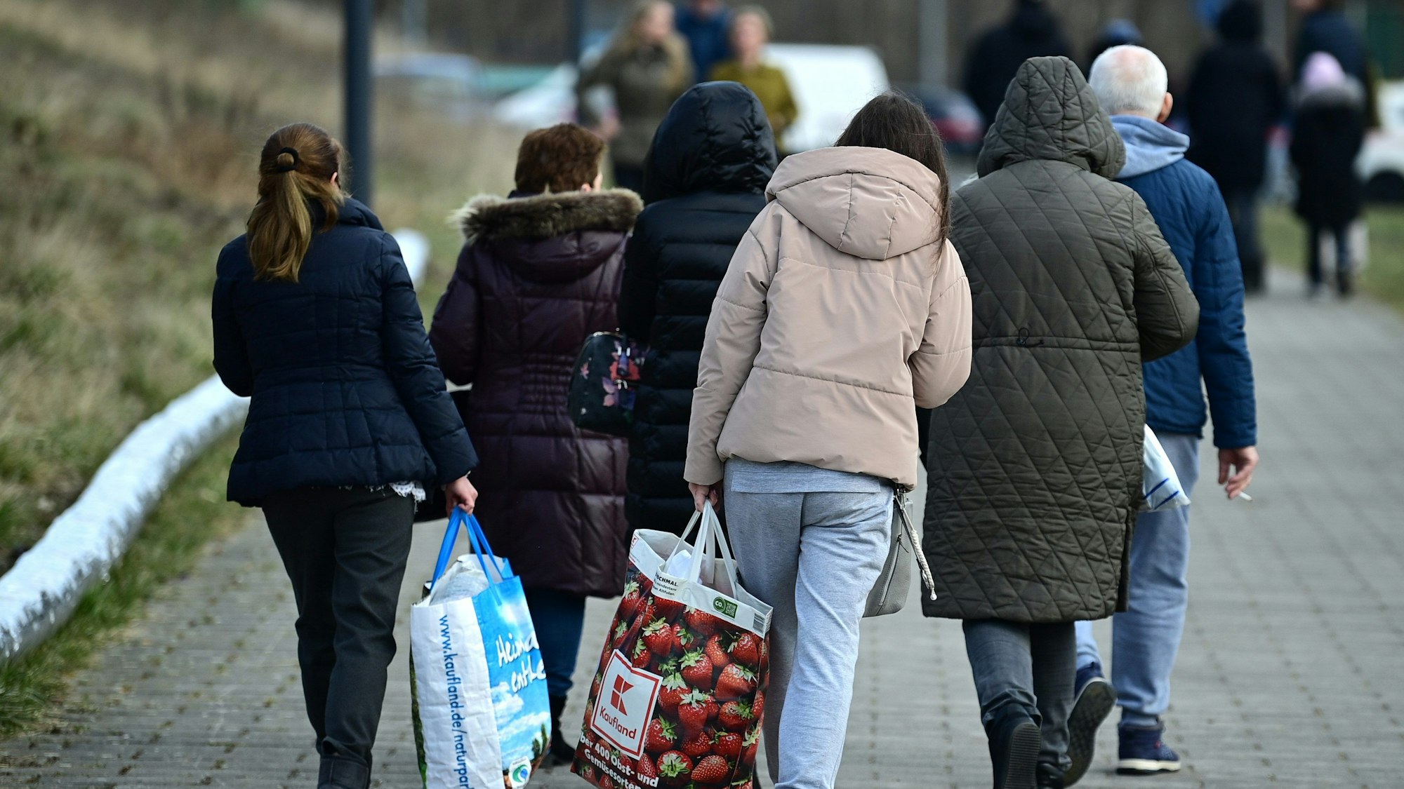 Ukrainische Flüchtlinge gehen nach ihrer Registrierung in der Orangerie der Biosphäre auf einem Weg entlang.
