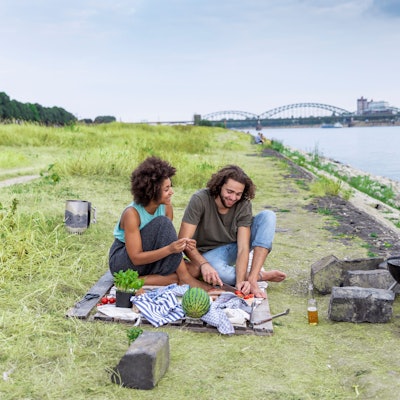 Eine Frau und ein Mann grillen am Kölner Rheinufer.