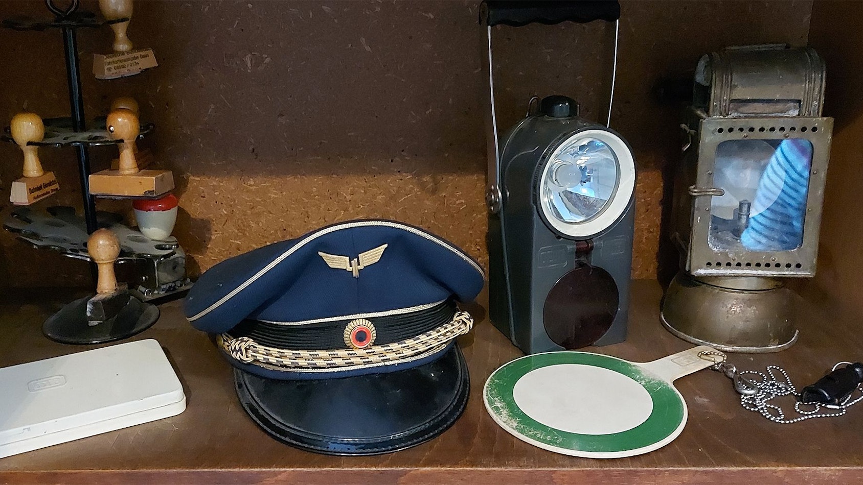Das Foto zeigt alte Bahnutensilien, darunter eine Dienstmütze, Stempel und eine Signalkelle.