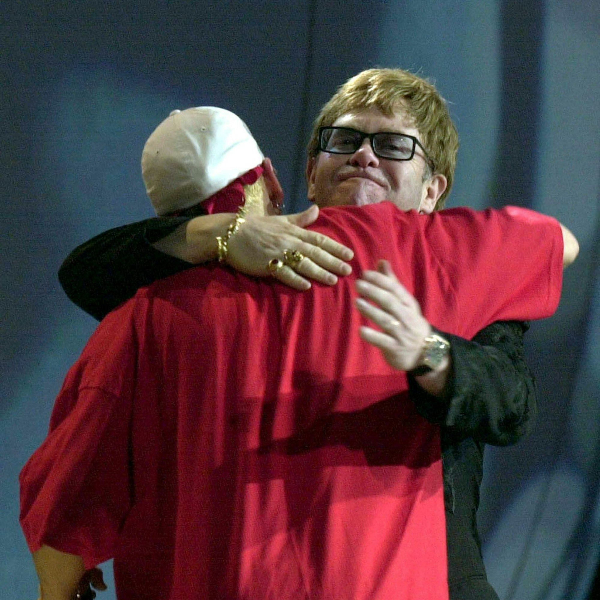 Elton John und Eminem umarmen sich auf der Bühne.