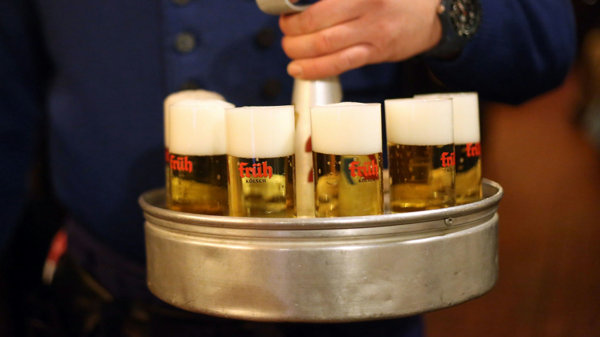 ARCHIV - Ein Köbes (Kellner) trägt am 10.12.2012 in Köln (Nordrhein-Westfalen) im Brauhaus Früh am Dom Kölsch-Bier aus. Foto: Oliver Berg/dpa (zu dpa "Neues aus der Szene" vom 09.06.2016) +++ dpa-Bildfunk +++