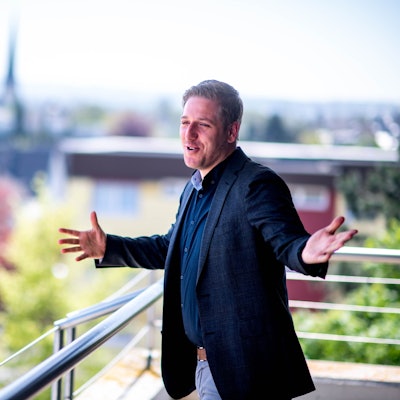 Das Bild zeigt den Landrat auf dem Balkon des Kreishauses. Er hat die Arme ausgebreitet.