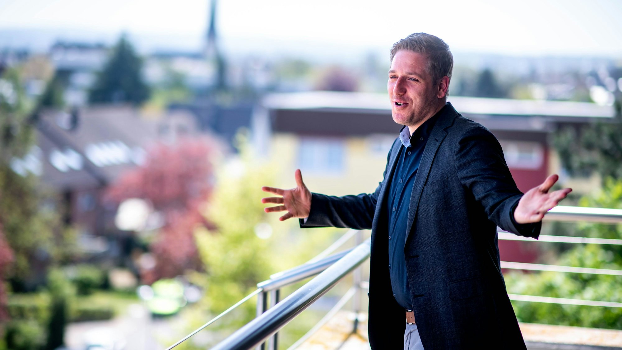 Das Bild zeigt den Landrat auf dem Balkon des Kreishauses. Er hat die Arme ausgebreitet.