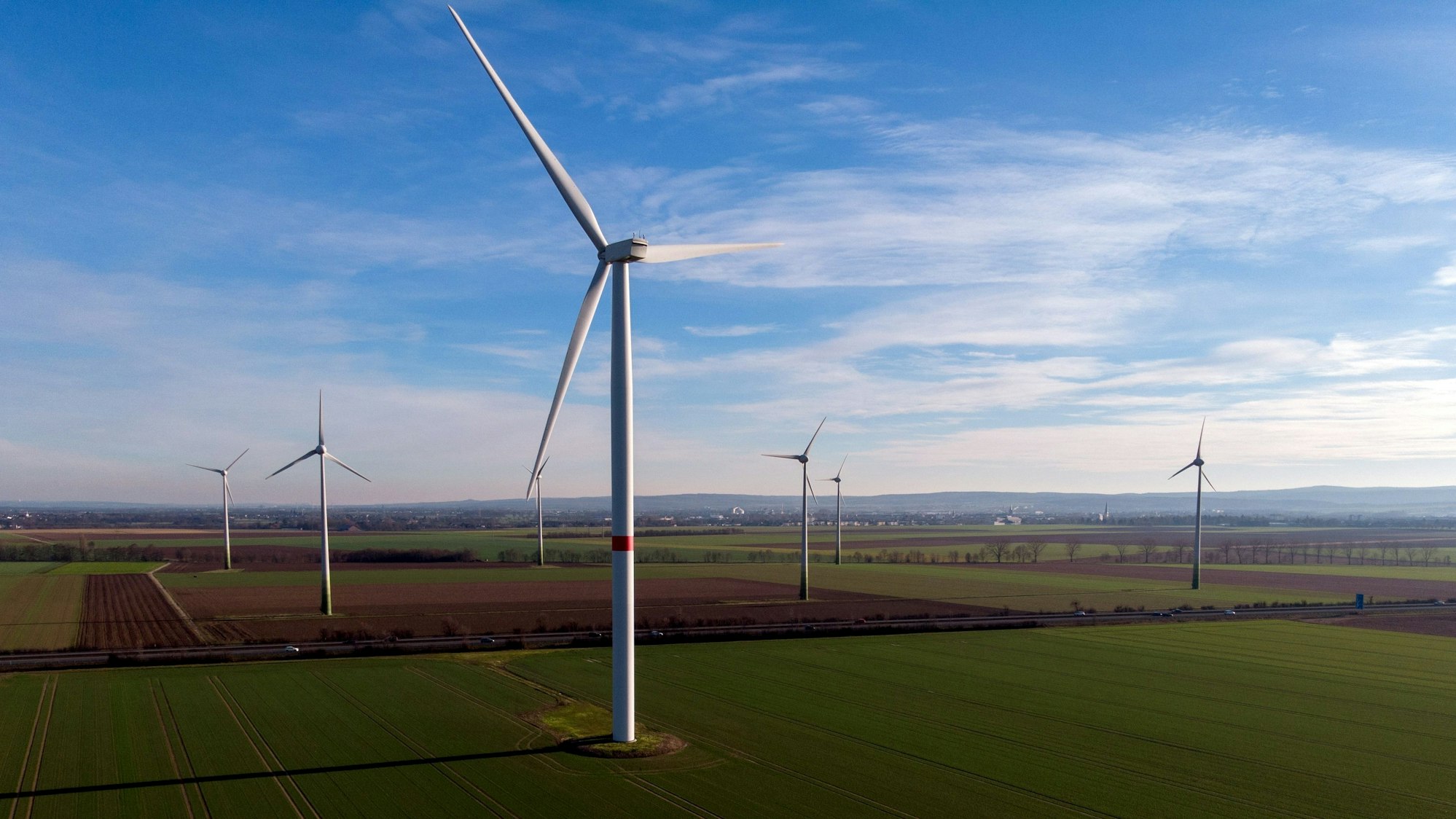 Eine Reihe von Windrädern stehen auf einem Feld.