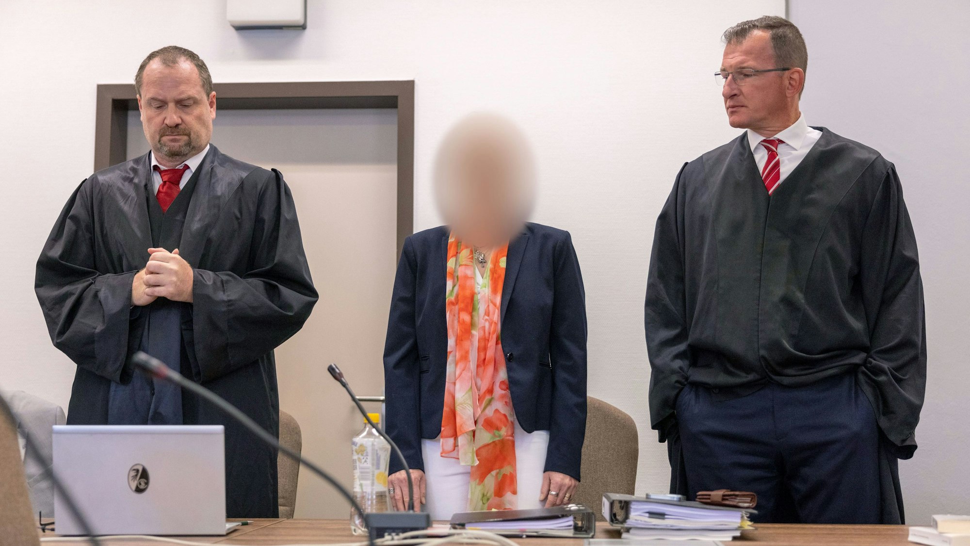 Die angeklagte Apothekerin (M) steht zwischen ihren Rechtsanwälten Morton Douglas (l) und Gerson Trüg (r) vor dem Kölner Landgericht.